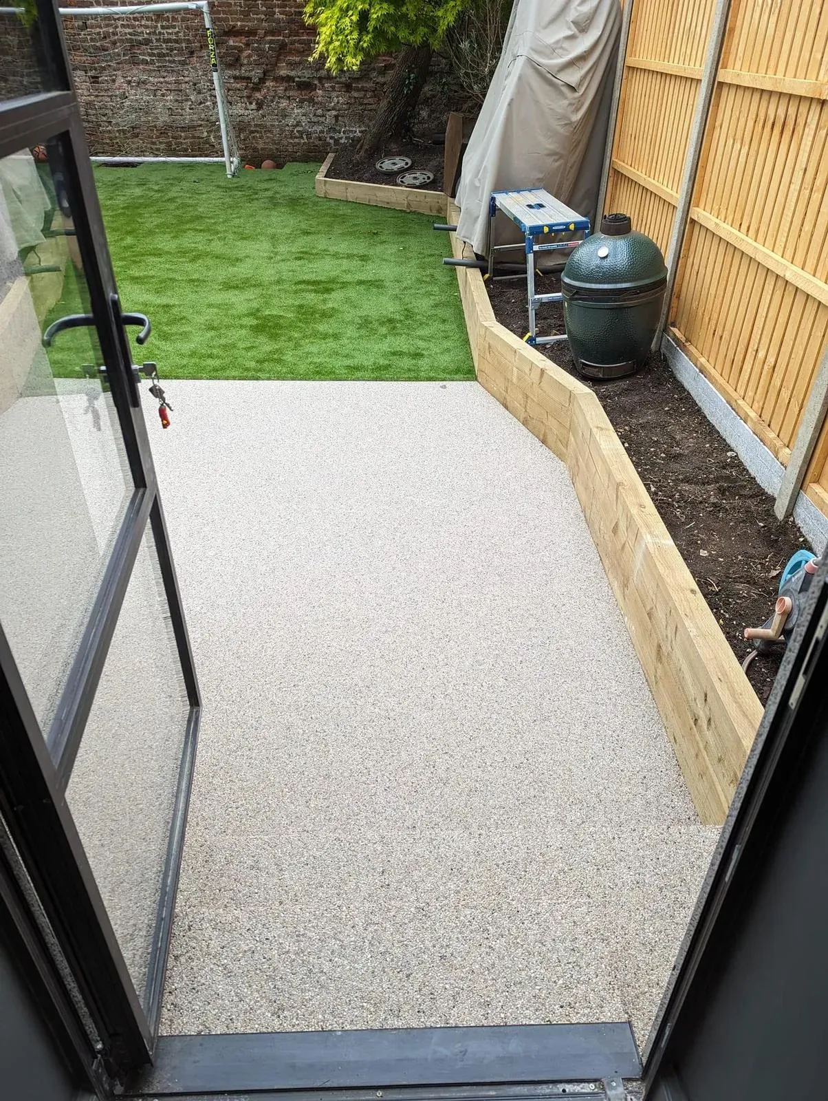 Resin patio and artificial grass lawn in a newly landscaped garden