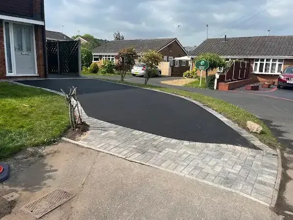 Newly laid tarmac driveway with neat grey block paving border